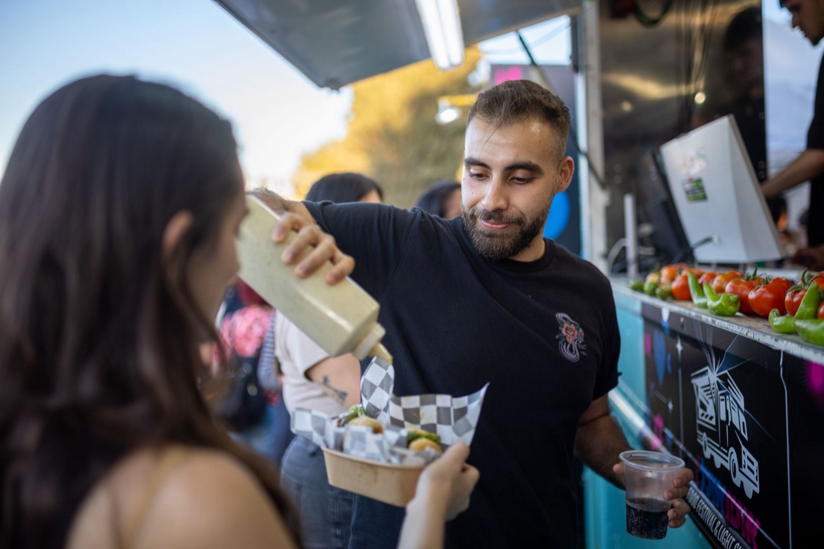 Street vendor with taco truck and customers in Los Angeles